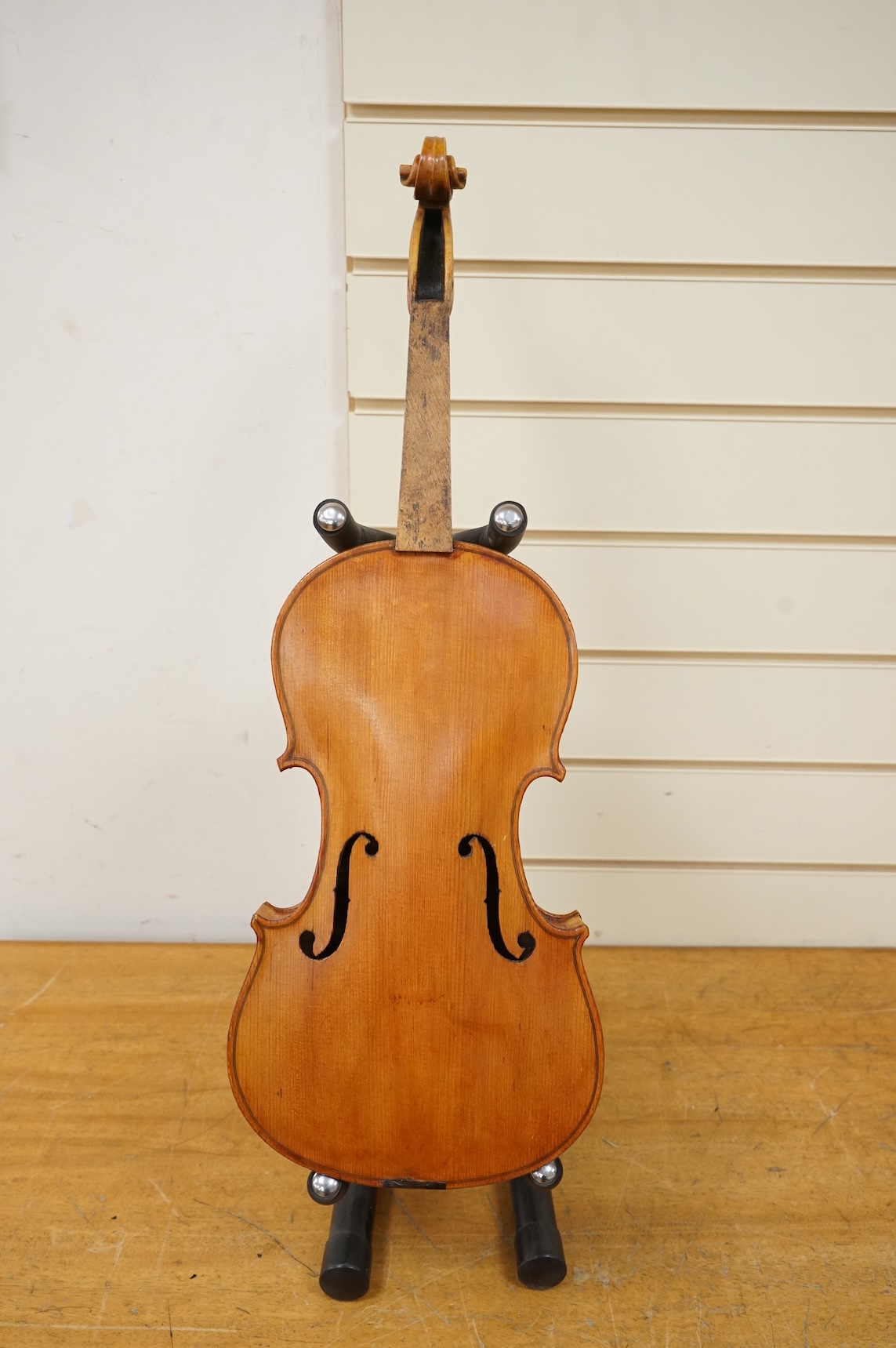 Three violins; a late 19th century German Stradivarius pattern violin, without label, a handmade violin (a.f.), with sound post crack, broken and repaired scroll, etc. and a Maidstone violin body, varnish stripped from t